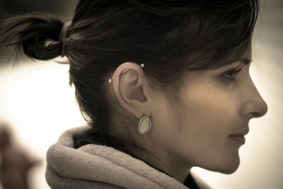 Close-up side view of young woman with pierced ear