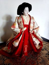 Young woman looking away while sitting in traditional clothing