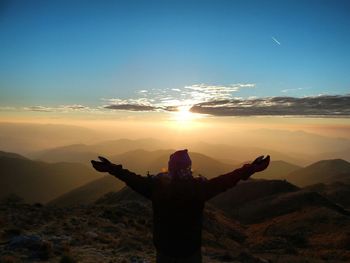 Silhouette of man looking at sunset