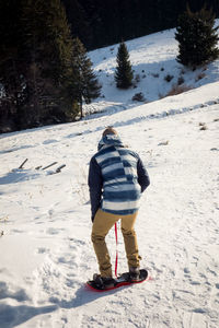 Man learning to snowboard during winter