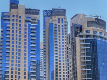 Low angle view of modern buildings against clear blue sky