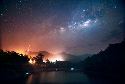 Scenic view of silhouette trees against sky at night