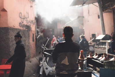 Rear view of people standing on street in city