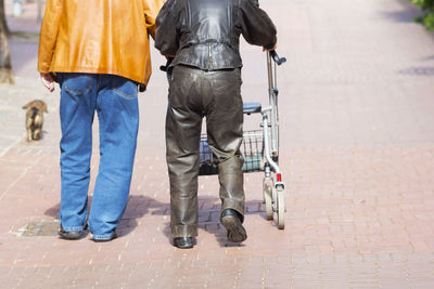 Low section of people walking on sidewalk