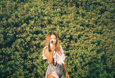 Portrait of woman standing by plants