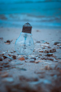 Close-up of bottle on beach