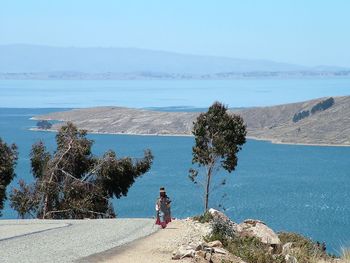 Woman looking at sea against sky