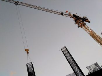 Low angle view of crane against clear sky