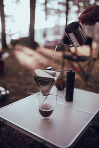 Close up photo of man preparing coffee at camping in forest.