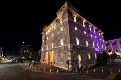 Low angle view of illuminated buildings against sky at night