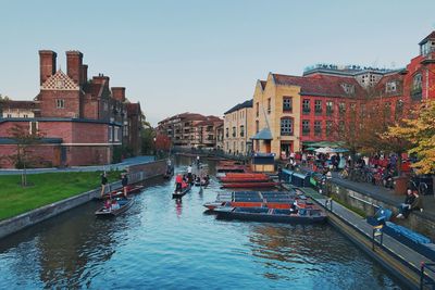 Boats in canal amidst buildings against sky