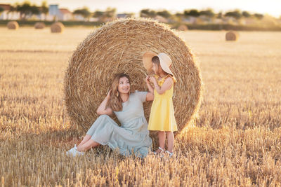 Rear view of woman standing on hay