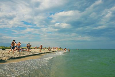People on beach against sky