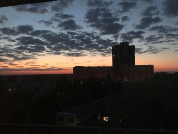 Silhouette buildings against sky during sunset