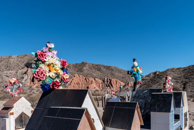 Low angle view of people on mountain against blue sky