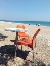 Chairs on beach against clear sky