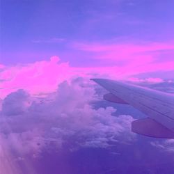 Airplane wing against sky during sunset