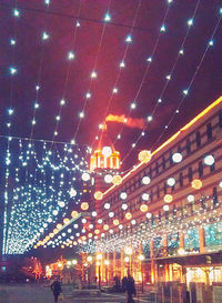 Low angle view of illuminated building against sky at night