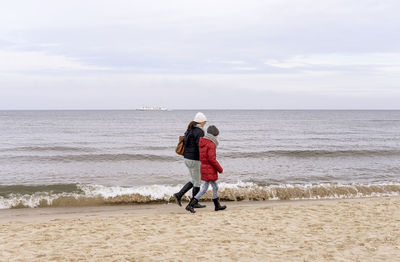 Full length of woman on beach against sky