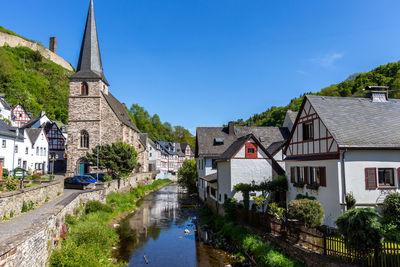 River elz with half-timbered houses and church in monreal, germany