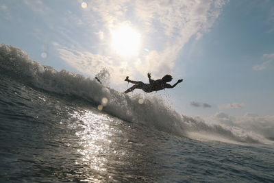 Surfer on a wave at sunset time