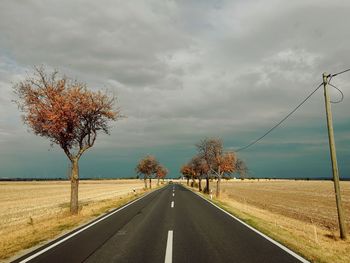 Empty road along landscape and against sky