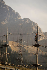 Man working on mountain against sky