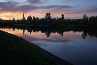 Reflection of building on water at sunset