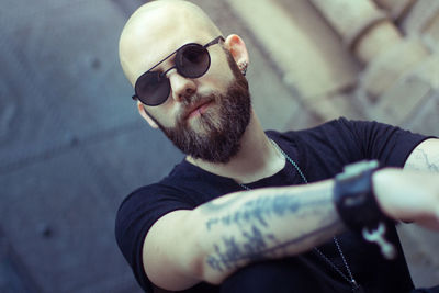 Close-up portrait of bald young man wearing sunglasses