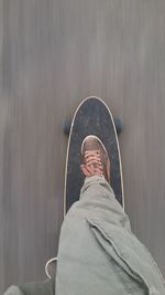 Low section of man skateboarding on road