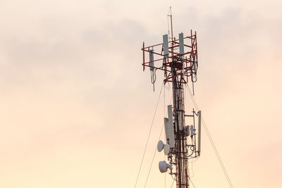 Low angle view of electricity pylon against sky during sunset