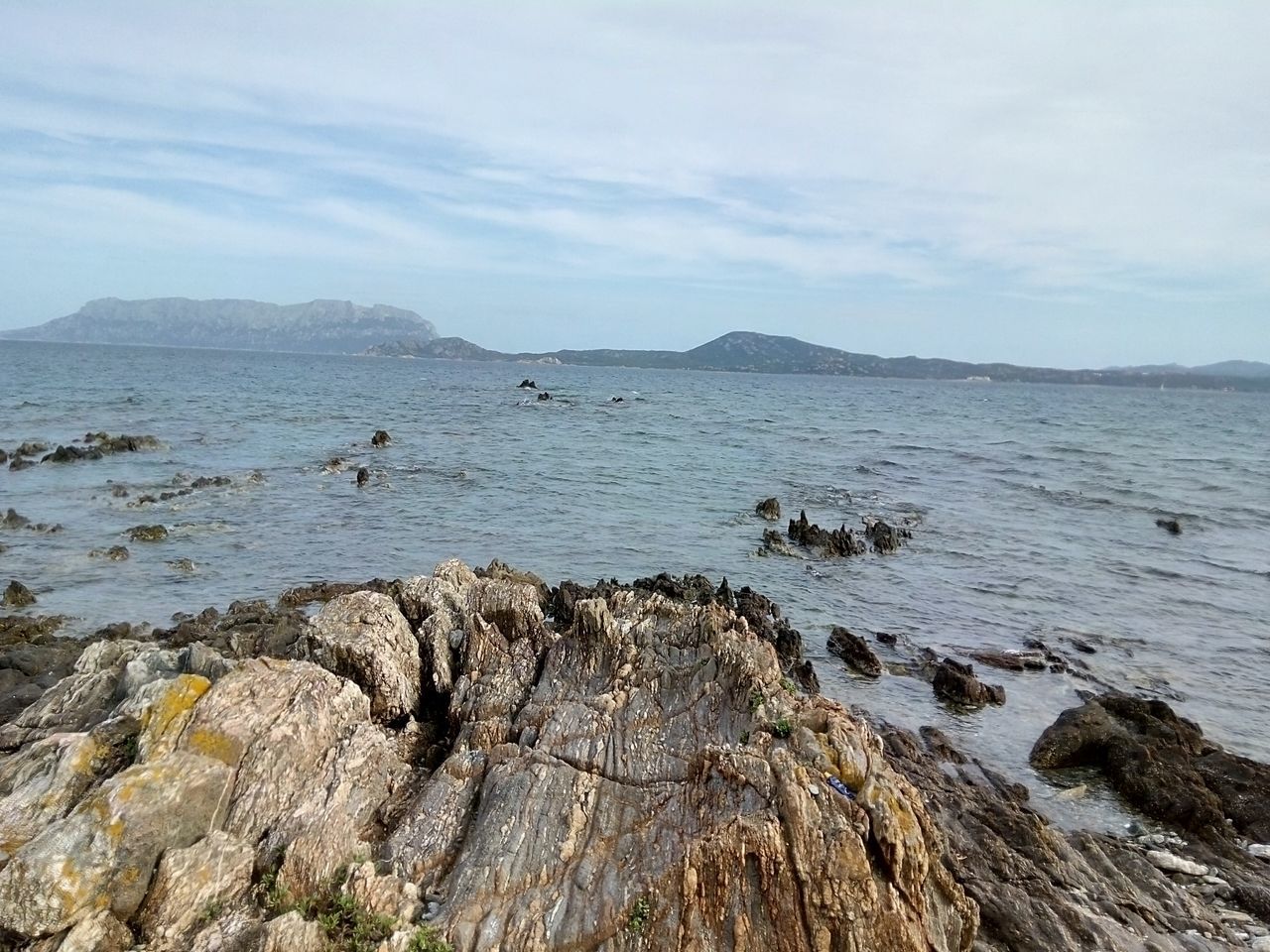 water, sky, tranquil scene, tranquility, sea, scenics, mountain, beauty in nature, rock - object, nature, rock formation, cloud - sky, idyllic, rock, day, outdoors, non-urban scene, remote, shore, beach