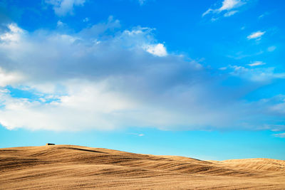 Scenic view of desert against blue sky