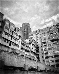 Low angle view of buildings against cloudy sky