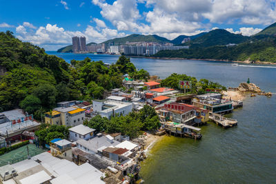 High angle view of buildings by sea against sky