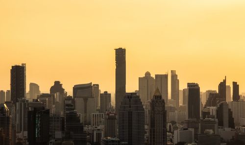 Skyscrapers in city against clear sky during sunset