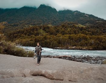 Woman standing on mountain against sky