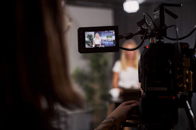 Young female news anchor in studio on camera