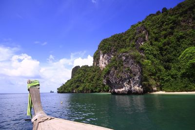 Scenic view of sea by mountains against sky