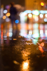 Defocused image of illuminated city street during rainy season