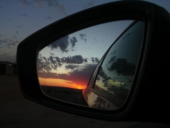 Cropped image of car on side-view mirror of car