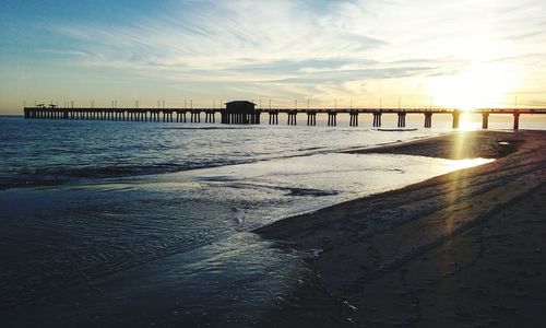 Bridge over sea against sky during sunset