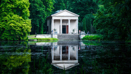 Built structure by lake against trees