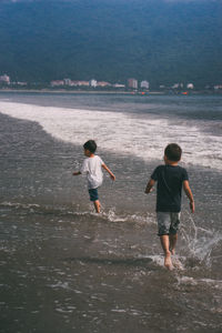 Rear view of boys on beach