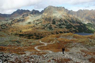 Man standing on rock against sky