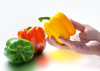 Close-up of hand holding yellow bell peppers