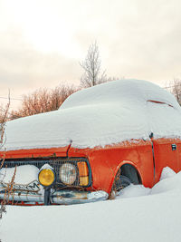 Abandoned car on snow covered field