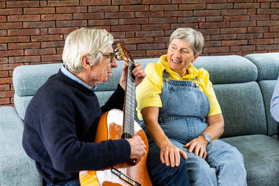 Portrait of senior couple sitting on sofa at home