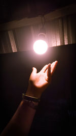 Midsection of person holding illuminated lamp