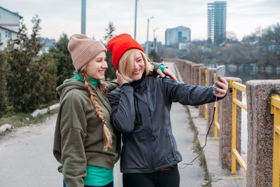 Women talking selfie while standing outdoors